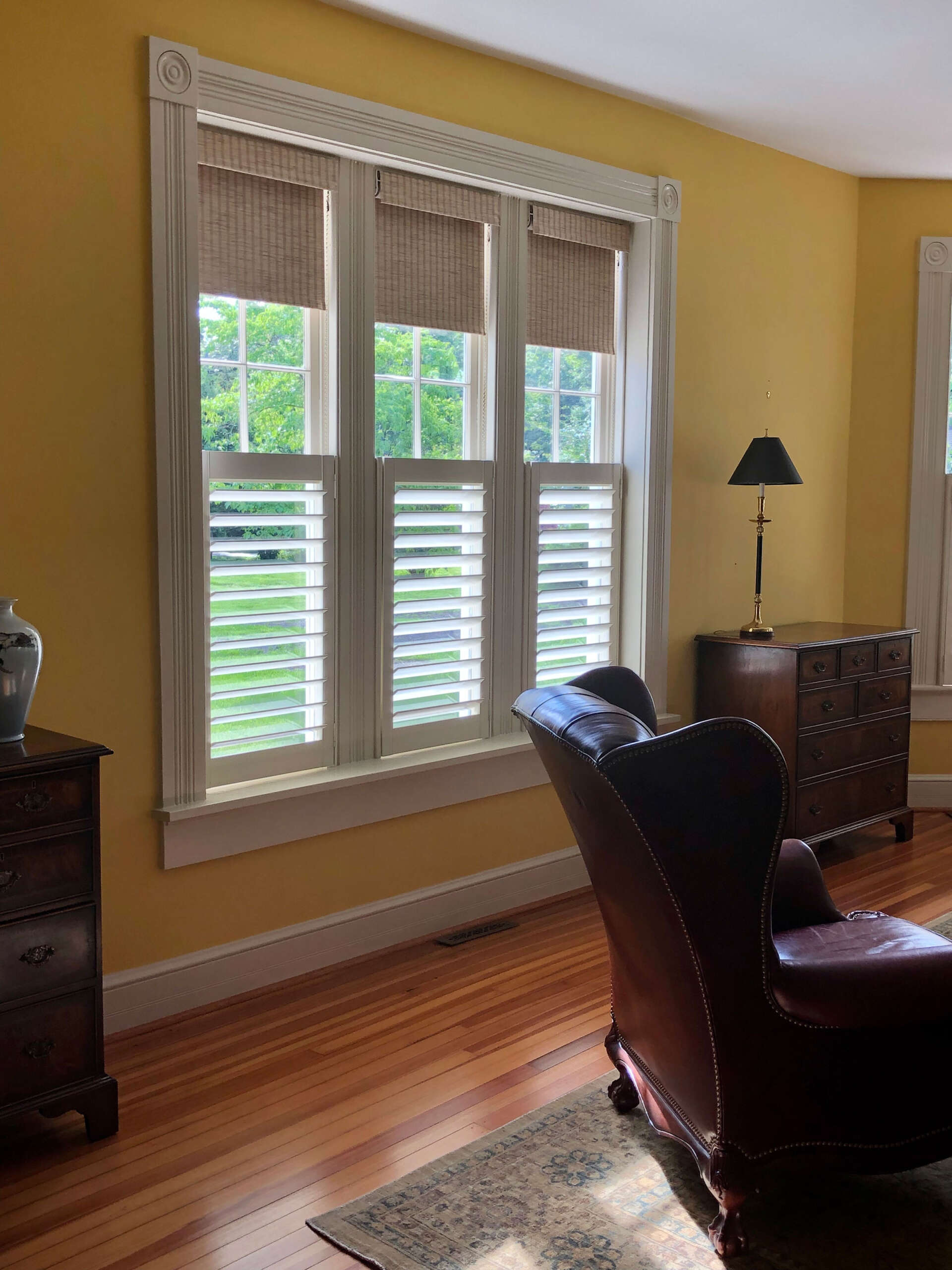 Shutter Company shutters and shades installed in living room